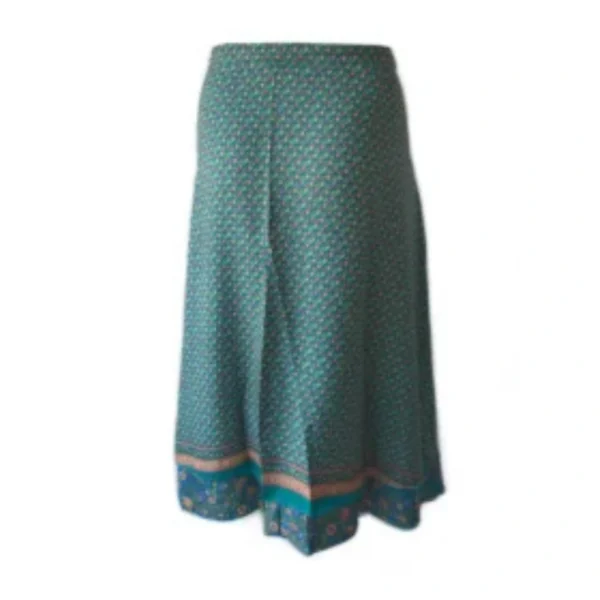Une femme porte une jupe verte et bleue, mettant en valeur un style élégant et coloré.