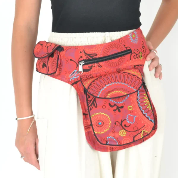 Une femme portant un sac banane à motifs paisley rouge et noir.