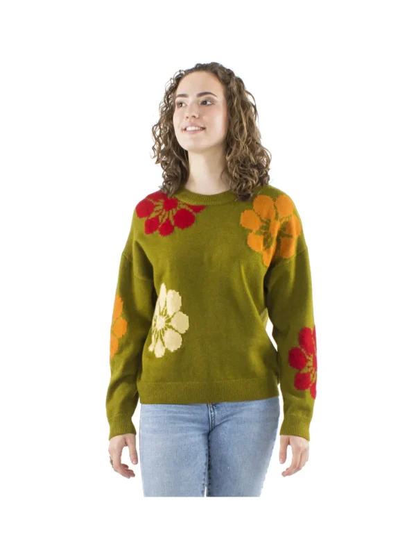 Femme portant un pull vert orné de fleurs multicolores, affichant un style vibrant et coloré.