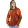 Femme portant un pull rouge orné de fleurs orange et vertes, affichant un style coloré et printanier.