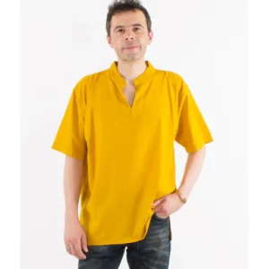 Un homme se tient devant un fond blanc, vêtu d'une chemise jaune éclatante.