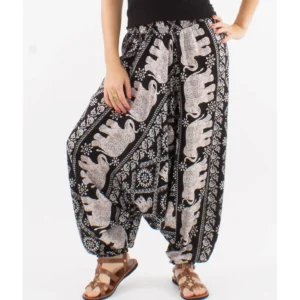 Une femme portant un pantalon harem à motif éléphant noir et blanc, affichant un style décontracté et original.