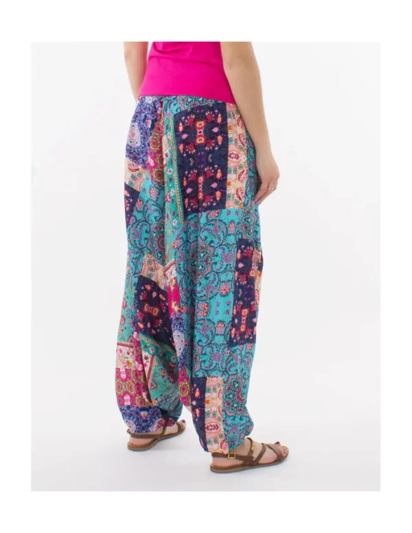 Une femme portant un pantalon harem coloré, affichant un style vibrant et décontracté.