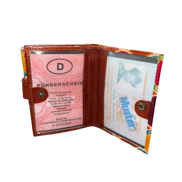 Porte-monnaie coloré avec une bandoulière en cuir marron et un motif vibrant.