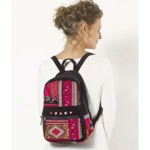 Une femme porte un sac à dos aux motifs colorés, ajoutant une touche vibrante à son style.