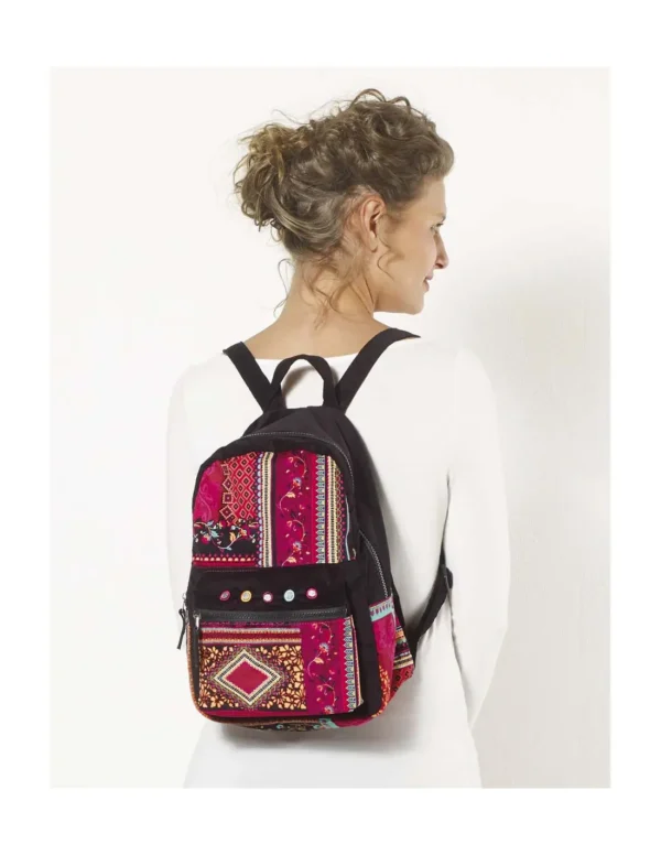 Une femme porte un sac à dos aux motifs colorés, ajoutant une touche vibrante à son style.