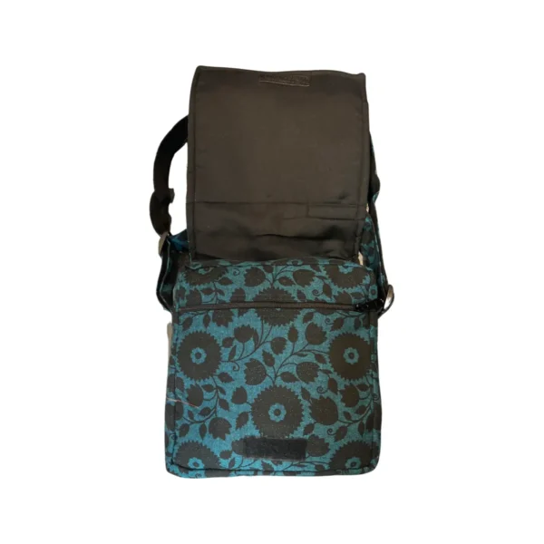 Sac à fleurs bleues avec une bandoulière noire, alliant élégance et praticité dans un design moderne.