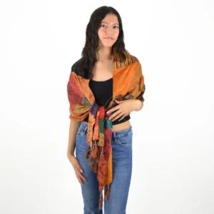 Femme portant une écharpe patchwork bohème en soie multicolore nouée sur un haut noir et un jean.
